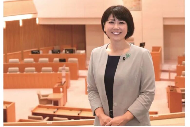 議会を背景に微笑む小川市長の写真
